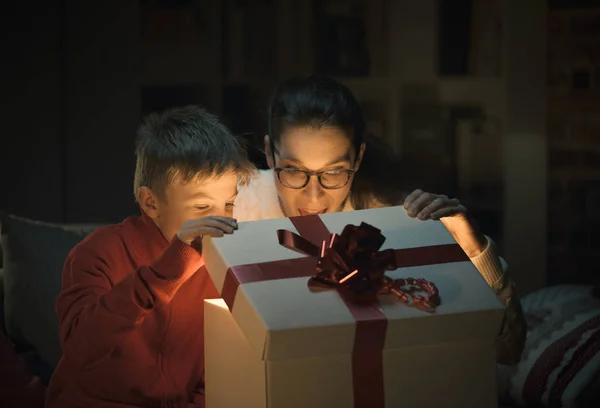 その快活な少年と母親の驚きの内部 休日や家族概念の素晴らしいクリスマス プレゼントを開く — ストック写真