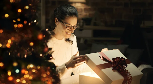 Glückliche Frau Öffnet Ein Zauberhaft Glänzendes Weihnachtsgeschenk Hause Weihnachtsbaum Vordergrund — Stockfoto