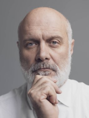 Çene üzerinde el ile poz emin üst düzey iş adamı