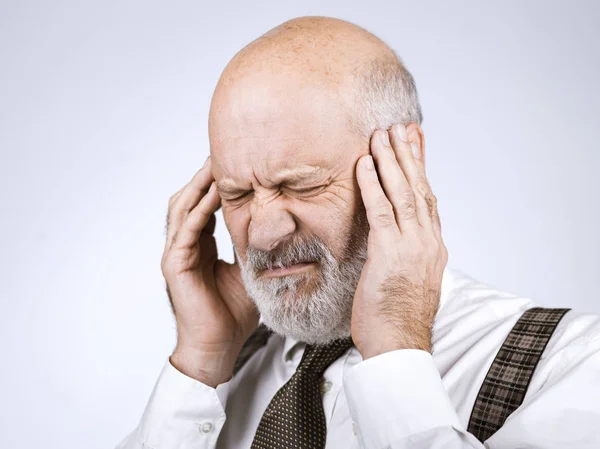 ひどい頭痛を持つ年配の男性彼は苦しみと混乱を感じています — ストック写真