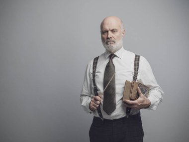 Kendine güvenen ciddi akademik Profesör eski kitaplar ile poz: geleneksel eğitim, bilgi ve disiplin kavramı