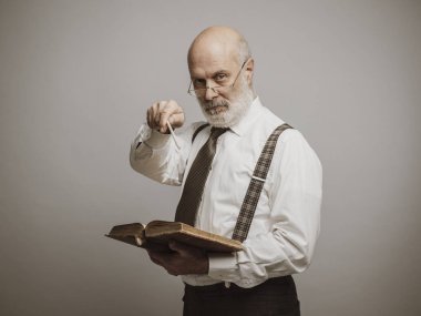 Bir kitap kameraya dönük ve aralarında en üst düzey akademik Profesör: Sınavlar ve geleneksel eğitim kavramı