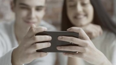 Bir smartphone bir arada tutan ve bir video izlerken arkadaşlar, onlar zevk gülümseyen ve