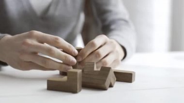 Akıllı kadın bir ahşap beyin teaser puzzle ile oynarken bir masa üzerinde bir çözüm bulur ve çözer
