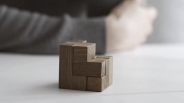 Akıllı kadın bir ahşap beyin teaser puzzle ile oynarken bir masa üzerinde bir çözüm bulur ve çözer