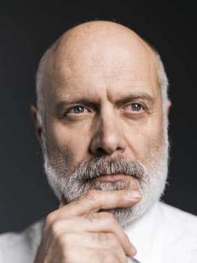 Çene ve düşünüyor, seyir ve alma kararları el ile poz emin olgun iş adamı