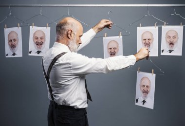 Olgun işadamı onun farklı kişilikleri portreler asılı ve bir karşılaştırma yapma bir koleksiyonu bakıyor: zihin kendini analiz ve duygular kavramı