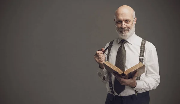 Lächelnder Hochschulprofessor Der Eine Pfeife Raucht Und Ein Buch Liest — Stockfoto