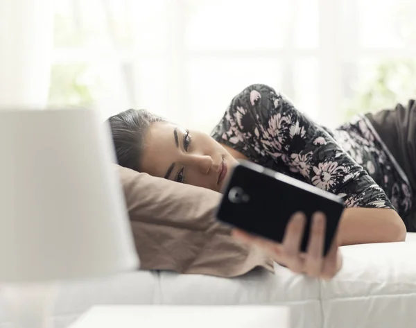 Jovem Bela Mulher Relaxando Cama Conectando Com Seu Smartphone Ela — Fotografia de Stock