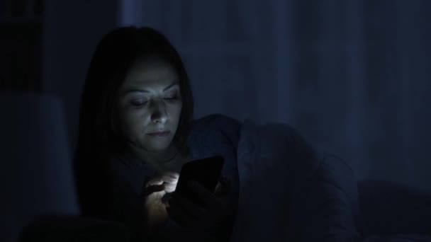 夜遅くまでベッドで横になっていると 彼女のスマート フォン ハイテク中毒とソーシャル メディア コンセプトとおしゃべり女 — ストック動画
