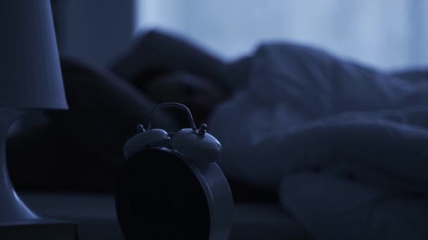朝早く鳴る昔ながらの目覚まし時計を押す女性それは床に落ちる — ストック動画