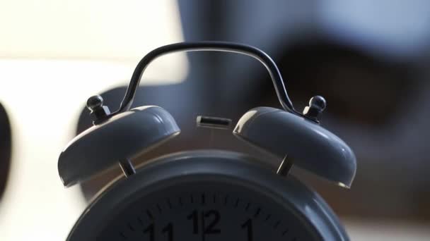 Réveil à l'ancienne avec cloches sonnant tôt le matin, une femme se réveille et l'arrête 