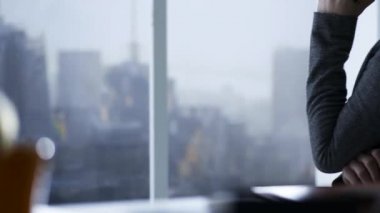 Kendine güvenen kurumsal iş kadını telefonla onun smartphone sahip bir pencere, iş ve iletişim kavramı yanında oturuyor