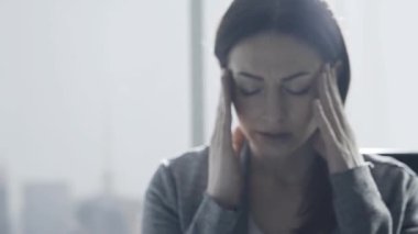 Kurumsal iş kadını çalışma ofisi ve kötü bir baş ağrısı olan, o onun tapınaklar çok dokunaklı ve çatık