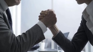 Genç iş kadını ve üst düzey yönetici bilek güreşi ofis masasında iş meydan okuma ve rakipleri kavramı