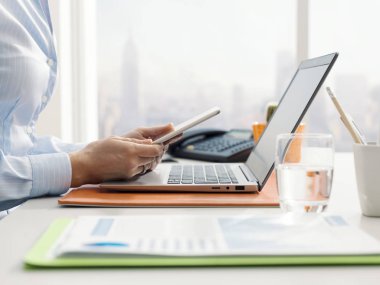 Ofisinde masada oturan ve bir dijital değmek perde tablet ile çalışma kurumsal iş kadını