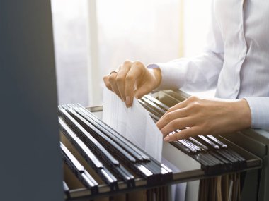 Dosya ve evrak dosya dolabında arama profesyonel kadın büro memuru