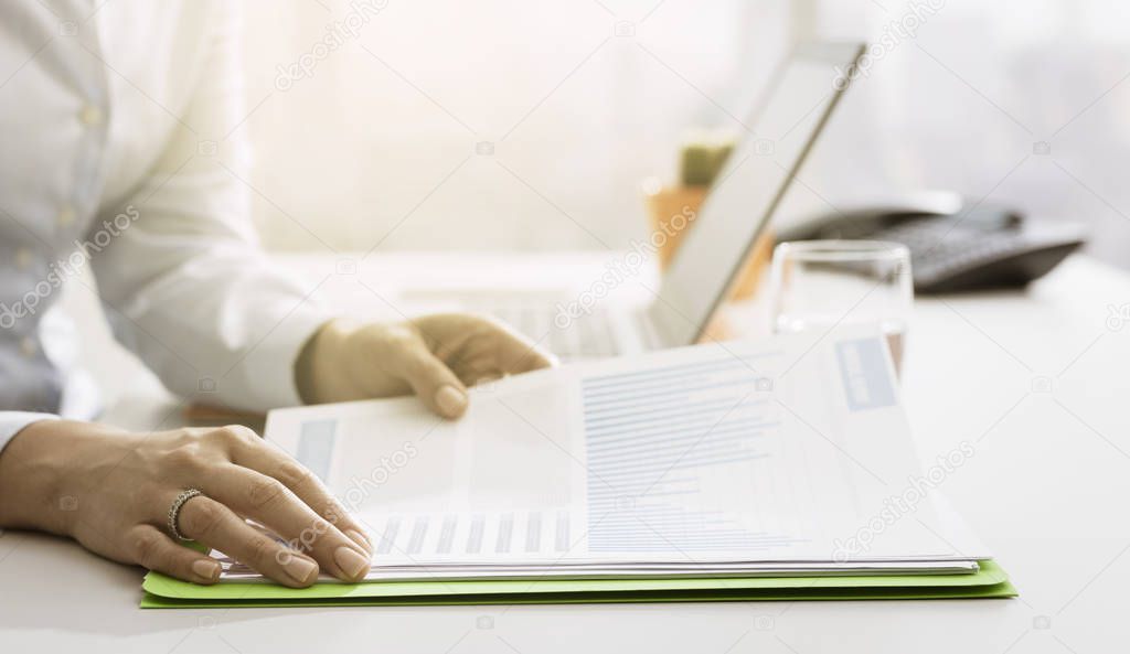 Expert businesswoman sitting at office desk and checking financial reports, business management and finance concept