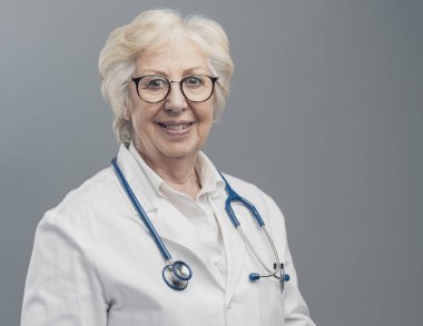 Poz ve gülümseyen kıdemli kadın doktor