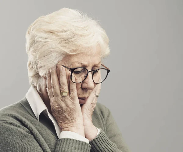 Sad lonely elderly woman posing with head in hands — Stock Photo, Image