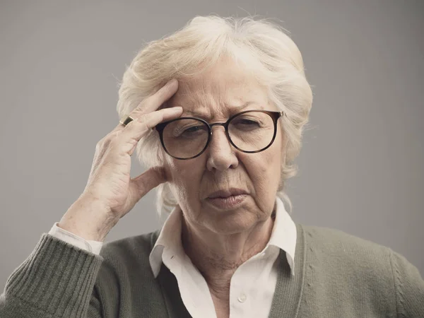 Alte Frau mit starken Kopfschmerzen — Stockfoto