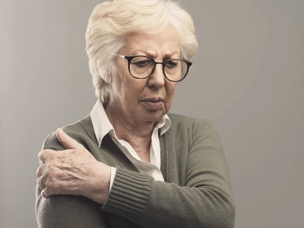 Triest senior dame met arm en gezamenlijke pijn — Stockfoto