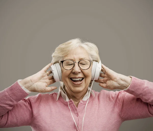 Happy starší žena nosí sluchátka — Stock fotografie