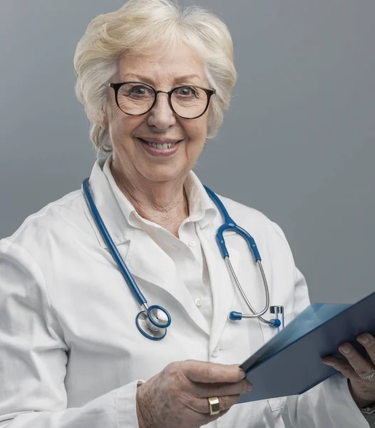 Médica idosa confiante posando e sorrindo — Fotografia de Stock