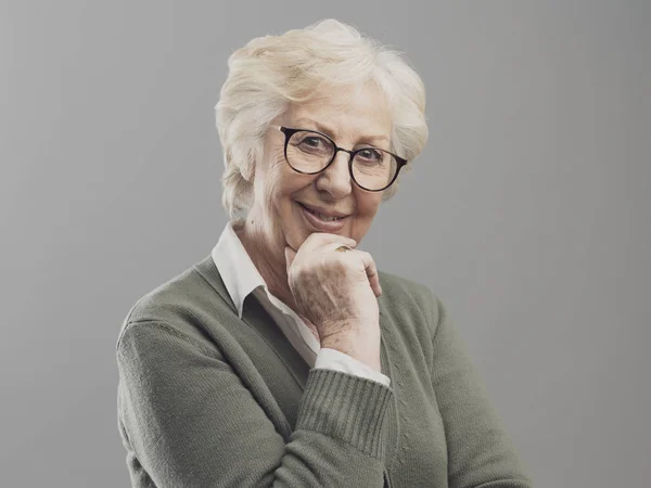 Glückliche Seniorin posiert auf grauem Hintergrund — Stockfoto