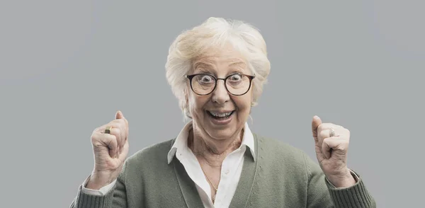 Весела старша леді святкує свою перемогу з піднятими кулаками — стокове фото