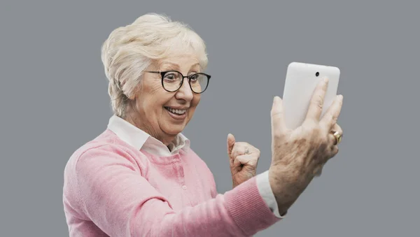 Feliz sorprendida señora mayor usando una tableta digital — Foto de Stock