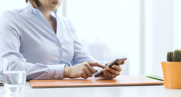 Geschäftsfrau arbeitet und vernetzt mit ihrem Smartphone — Stockfoto