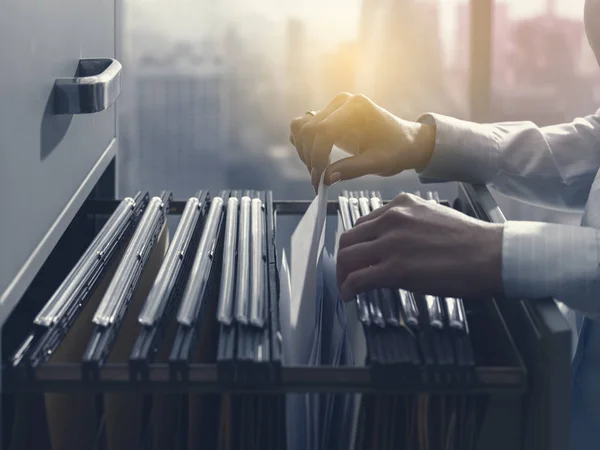 Office clerk searching files in the filing cabinet — Stock Photo, Image