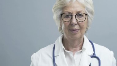 Gülümseyen kıdemli kadın doktor stetoskop ile