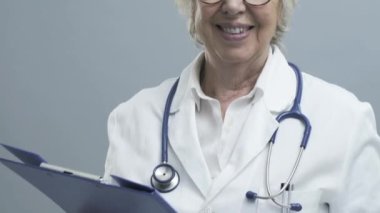Gülümseyen kıdemli kadın doktor stetoskop ile