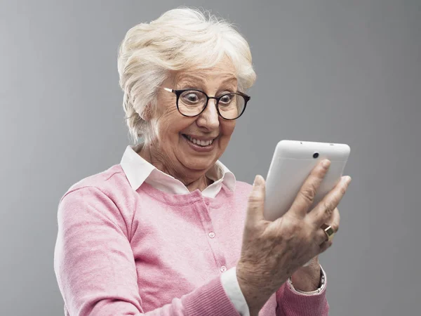 Szczęśliwy zaskoczony starszy pani przy użyciu cyfrowego tabletu — Zdjęcie stockowe