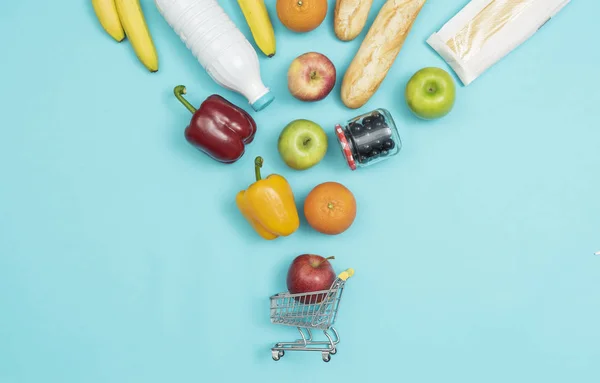 Grocery shopping products falling into a trolley — Stock Photo, Image