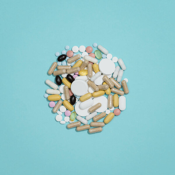 A lot of assorted pills and medicines on blue background
