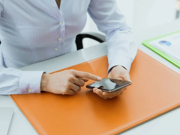 Geschäftsfrau arbeitet und vernetzt mit ihrem Smartphone — Stockfoto