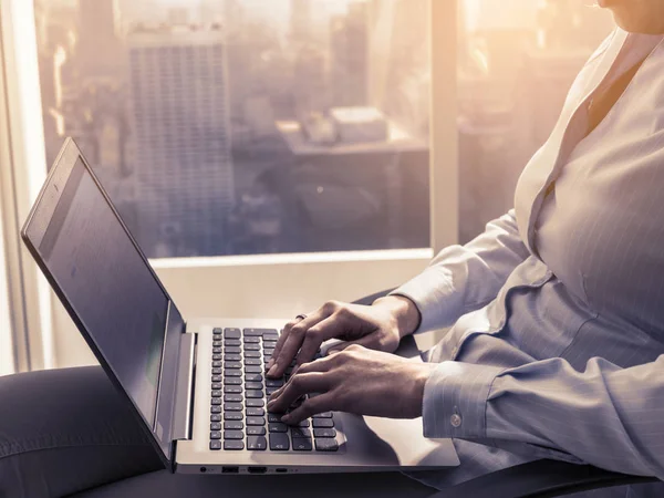 Businesswoman working with a laptop next to a window — Stock Photo, Image
