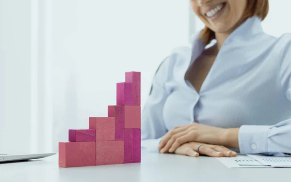 Mujer de negocios sonriente construyendo una carta financiera exitosa — Foto de Stock