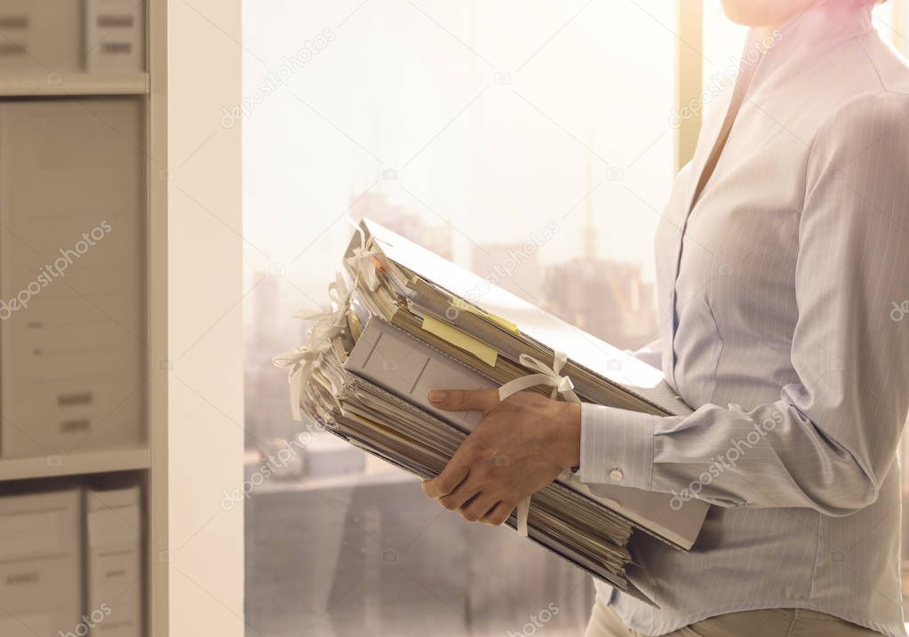 Office worker carrying paperwork in the office