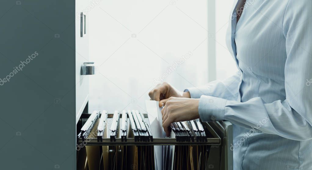 Office clerk searching files in the filing cabinet