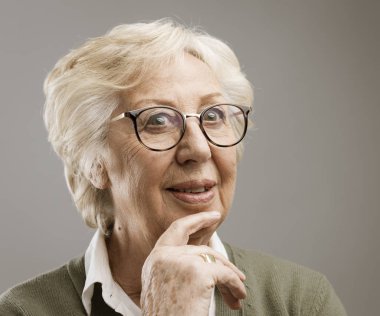 Çene üzerinde el ile düşünme gülümseyen kadın kıdemli