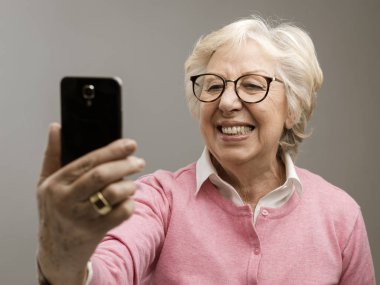 Selfies onun smartphone ile alarak mutlu kadın kıdemli
