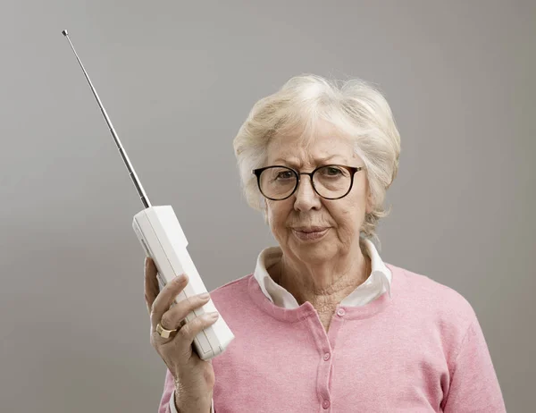 Gefrustreerd senior vrouw met behulp van een oude telefoon — Stockfoto