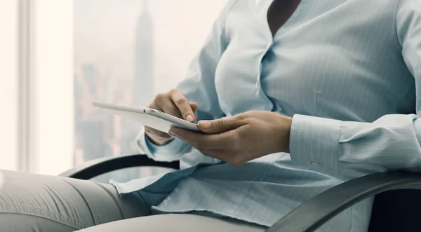 Geschäftsfrau verbindet sich im Büro mit ihrem Tablet — Stockfoto