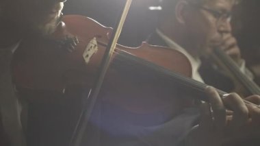 Senfonik orkestra sahnede klasik müzik konseri çalıyor