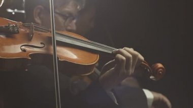 Senfonik orkestra sahnede klasik müzik konseri çalıyor