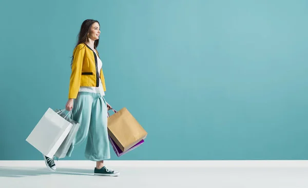 Leende kvinna gå och hålla shoppingväskor — Stockfoto
